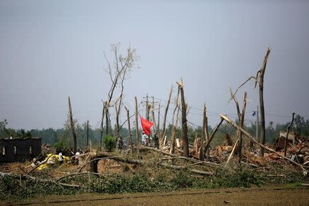 Rescue workers stand on a damaged house after a tornado hit Funing on Thursday, in Yancheng, Jiangsu province, June 25, 2016. REUTERS/Aly Song