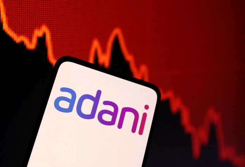 FILE PHOTO: Illustration shows Adani logo and decreasing stock graph