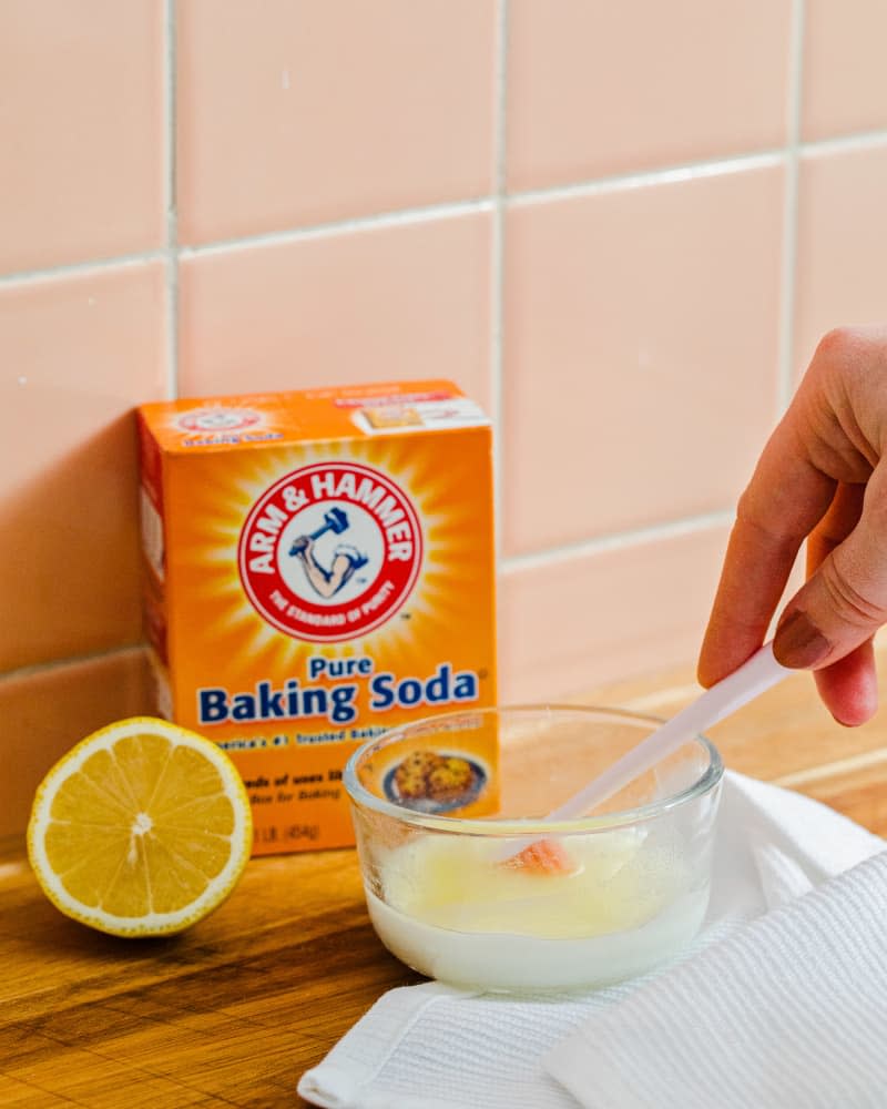 Mixing baking soda and lemon to make paste for cleaning tile