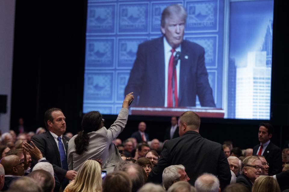 A demonstrator is led away as Republican presidential candidate Donald Trump delivers an economic policy speech to the Detroit Economic Club, Monday, Aug. 8, 2016, in Detroit. (Photo: Evan Vucci/AP)