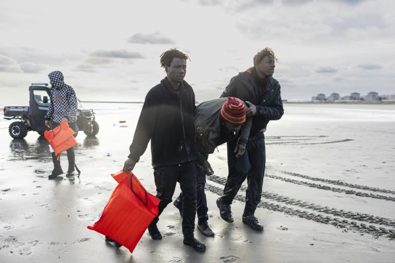 Unos migrantes sudaneses ayudan a otro tras su intento fallido de abordar un bote de contrabandistas para cruzar el canal de la Mancha el 26 de abril de 2024 en una playa de Gravelines, en el norte de Francia (Sameer al Doumy)