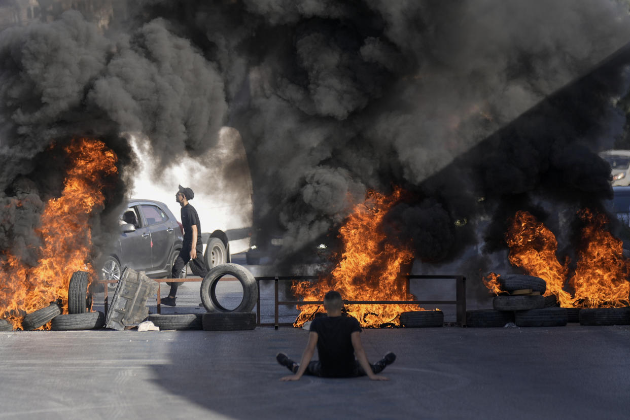 Tires set fire by Palestinians burn at the site where two Palestinians were shot and killed by the Israeli army in the Jalazone refugee camp near the city of Ramallah, West Bank, Monday, Oct. 3, 2022. Palestinian officials say the Israeli military has killed two Palestinians in the occupied West Bank. The Israeli military says it was on an arrest raid early Monday and alleges the two suspects tried to ram their car into soldiers, a claim that could not be independently verified. (AP Photo/Majdi Mohammed)