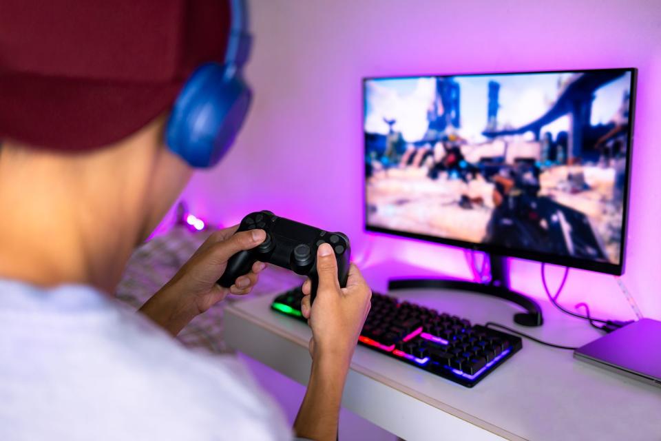 <p>Getty</p> A man playing online video games with his friends (stock image)