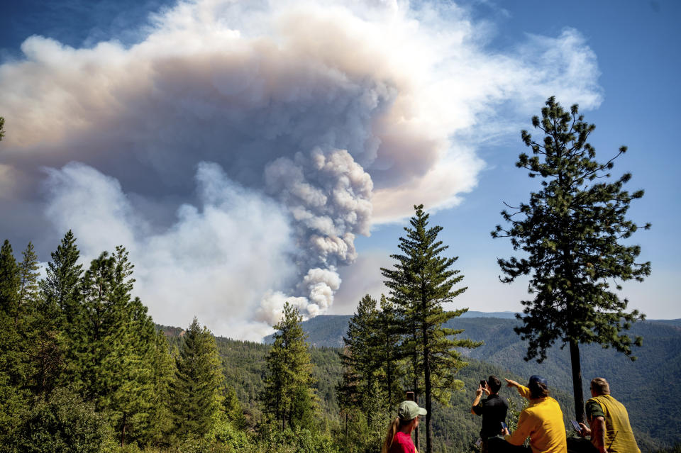 Firefighters and residents in the Foresthill community of Placer County, Calif., watch the as a plume rises from the Mosquito Fire on Thursday, Sept. 8, 2022. (AP Photo/Noah Berger)
