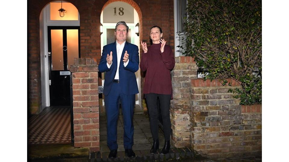 Keir and Victoria Starmer clapping outside their home