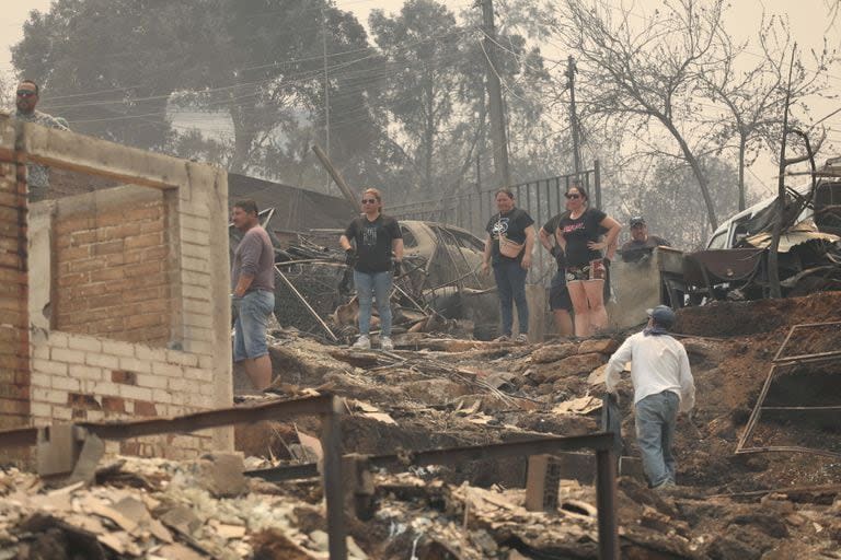 Personas observan los escombros de casas destruidas por un incendio forestal, en Viña del Mar, Chile(Xinhua/Str) (jv) (jg) (da)