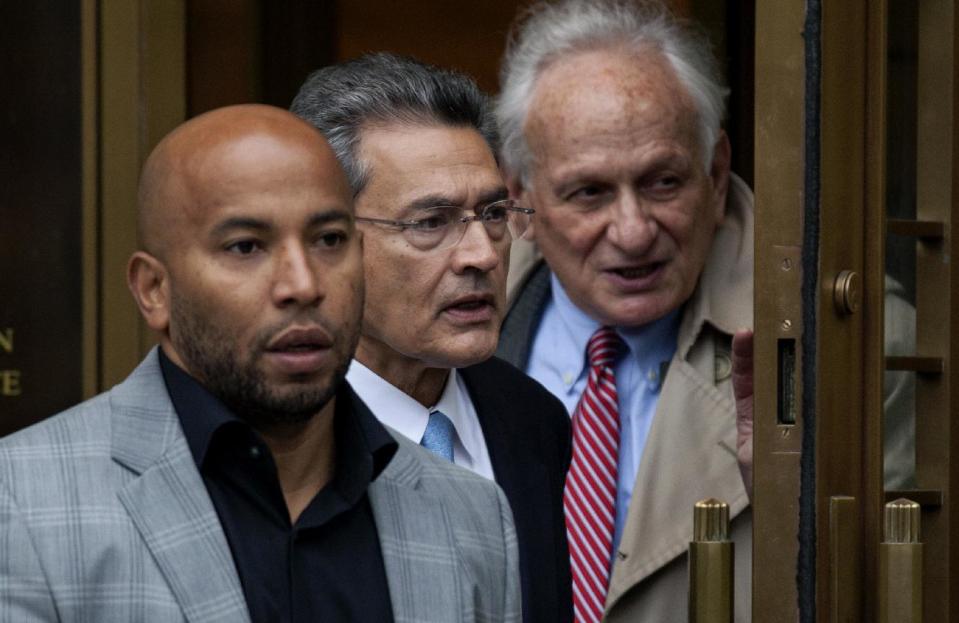 Rajat Gupta, center, leaves federal court in New York on Wednesday, Oct. 24, 2012 after the former Goldman Sachs and Procter & Gamble Co. board member was sentenced Wednesday to 2 years in prison for feeding inside information about board dealings with a billionaire hedge fund owner who was his friend. At right is Gupta's attorney, Gary Naftalis. (AP Photo/Craig Ruttle)