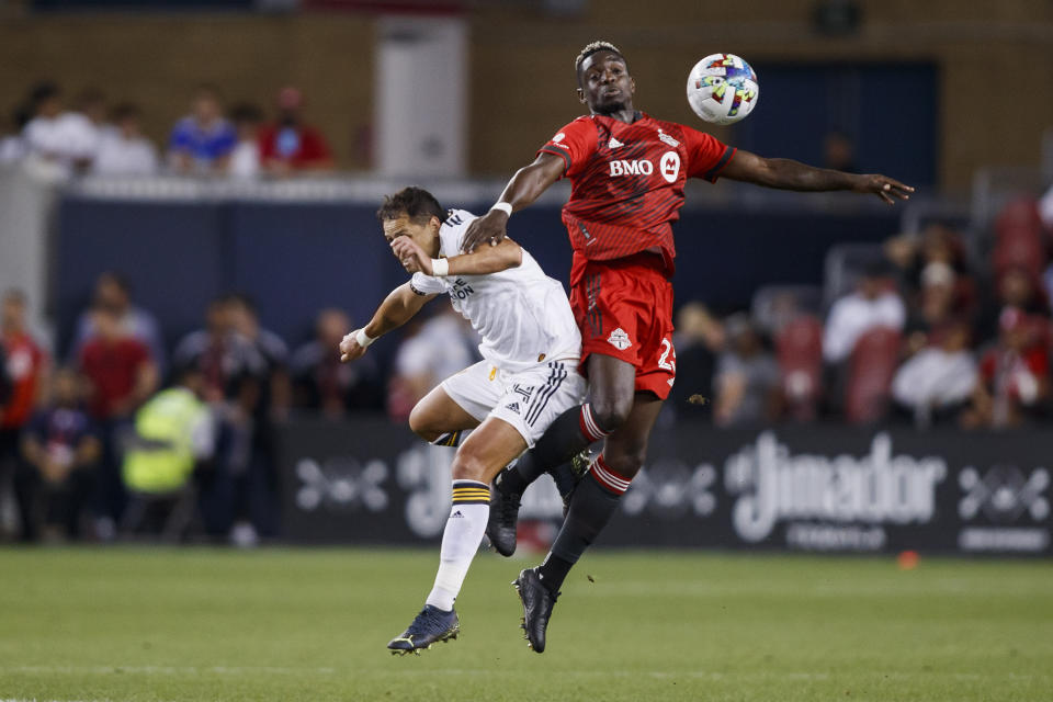 Toronto FC defender Chris Mavinga (23) and LA Galaxy forward Javier Hernández (14) jump for a ball during the first half of an MLS soccer game in Toronto on Wednesday, Aug. 31, 2022. (Cole Burston/The Canadian Press via AP)