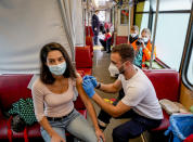 A woman receives her first vaccination in the so called "vaccination express" tram in central Frankfurt, Thursday, Nov. 4, 2021. About 100 people are vaccinated every day in two trams. (AP Photo/Michael Probst)