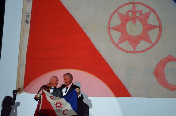 Filmmaker James Cameron stands with Explorers Club president Alan Nichols at the March 16, 2013 Explorers Club dinner. The two are holding the Explorers Club flag Cameron took on his 2011 journey to the deepest spot in the ocean.