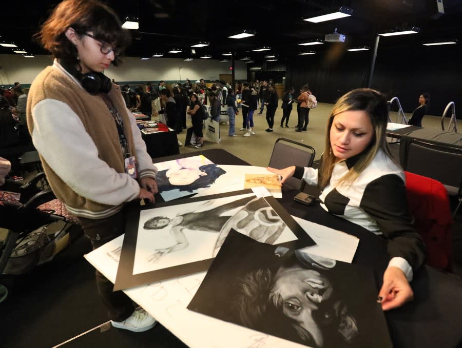 Marina Suarez, left, an art student at Bel Air High School, has her charcoal and chalk drawings critiqued by Cleo Arevalo, Assistant Professor of Art at EPCC Northwest Campus.