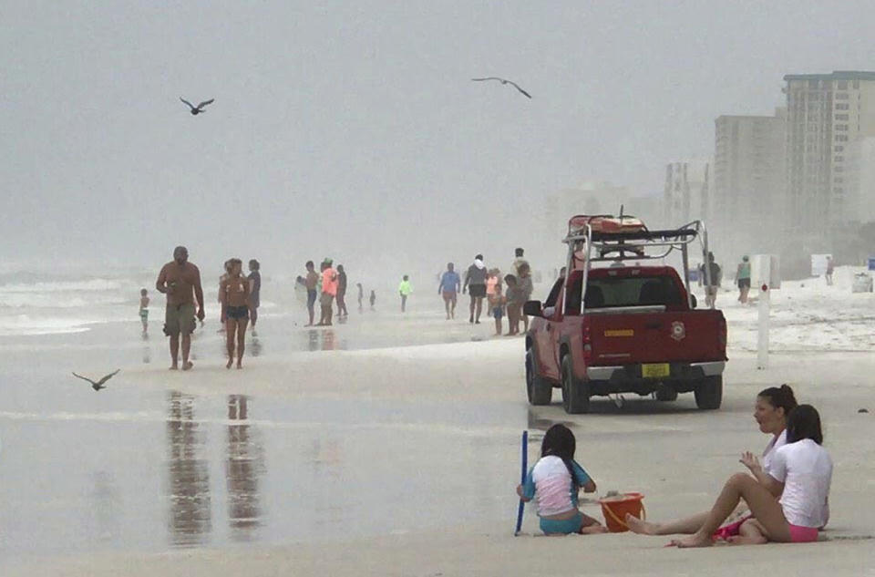 <p>A Destin Beach Safety truck drives past tourists as it patrols the shoreline along Destin, Fla., on June 21, 2017. (Photo: Annie Blanks/Northwest Florida Daily News via AP) </p>