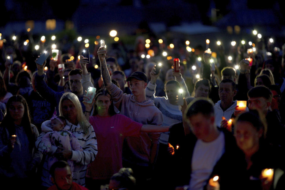 People attend a vigil for the victims of the mass shooting in Plymouth, England, Friday Aug. 13, 2021. Six people, including the offender, his own mother and a three-year old girl and her father, died of gunshot wounds in a firearms incident on Thursday evening. (Ben Birchall/PA via AP)