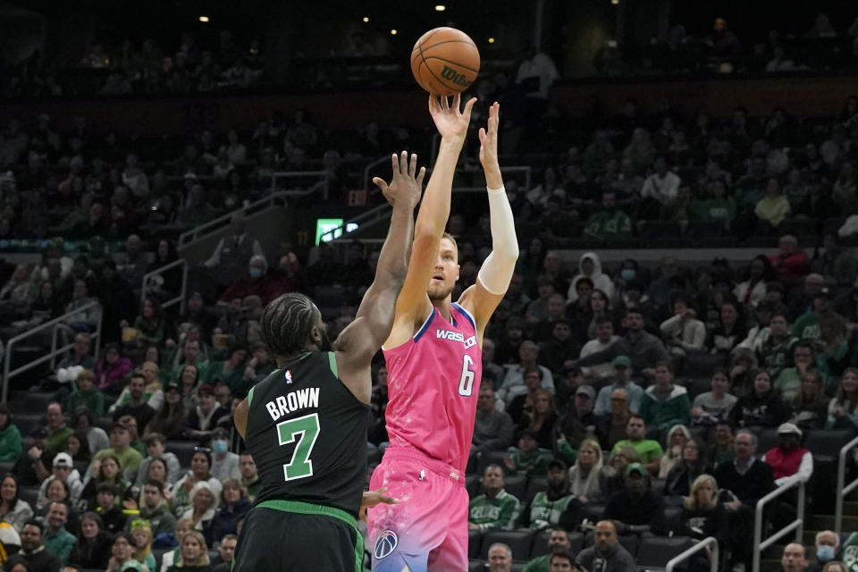 Washington Wizards center Kristaps Porzingis (6) shoots against Boston Celtics guard Jaylen Brown (7) during the first half of an NBA basketball game Sunday, Nov. 27, 2022, in Boston. (AP Photo/Mary Schwalm)