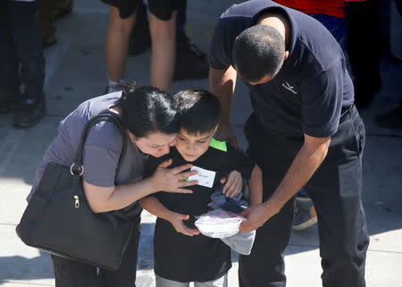 REFILE -- CORRECTING TYPO -- A student who was evacuated after a shooting at North Park Elementary School is embraced after groups of them were reunited with parents waiting at a high school in San Bernardino, California, U.S. April 10, 2017. REUTERS/Mario Anzuoni