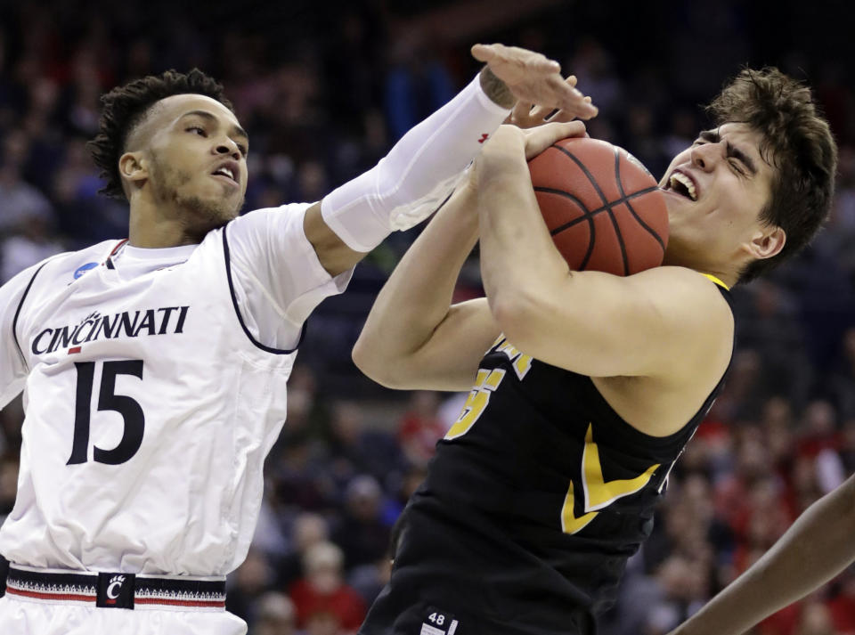 <p>Iowa’s Luka Garza (55) grabs a rebound ahead of Cincinnati’s Cane Broome (15) in the first half during a first round menâs college basketball game in the NCAA Tournament in Columbus, Ohio, Friday, March 22, 2019. (AP Photo/Tony Dejak) </p>