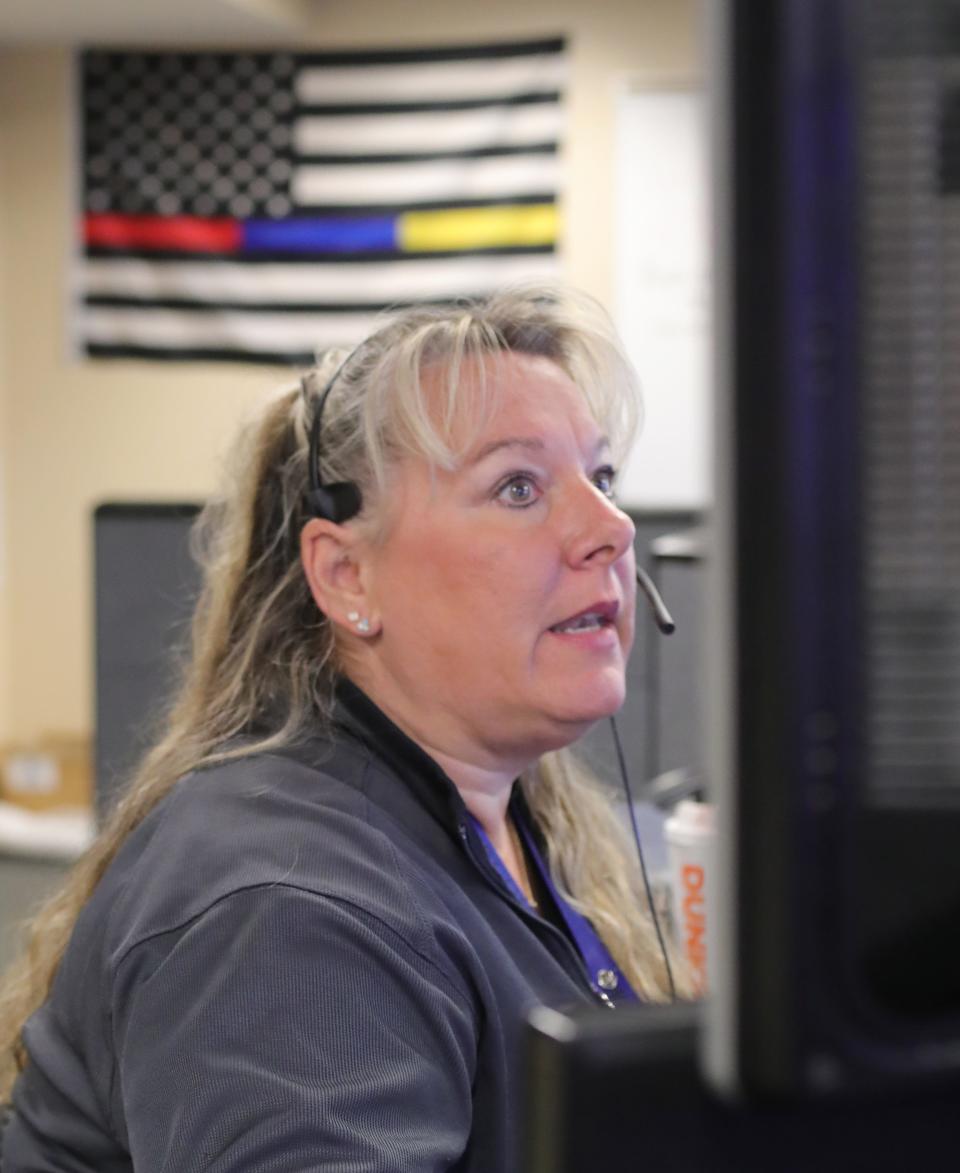 Kim Savula, a dispatcher for Norton, Copley and Barberton, helps a caller at the joint dispatching center in Norton.