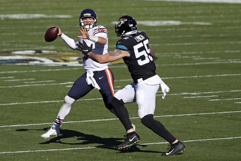 Chicago Bears quarterback Mitchell Trubisky, left, looks for a receiver as Jacksonville Jaguars defensive end Aaron Lynch (59) tries to stop him during the first half of an NFL football game, Sunday, Dec. 27, 2020, in Jacksonville, Fla. (AP Photo/Stephen B. Morton)
