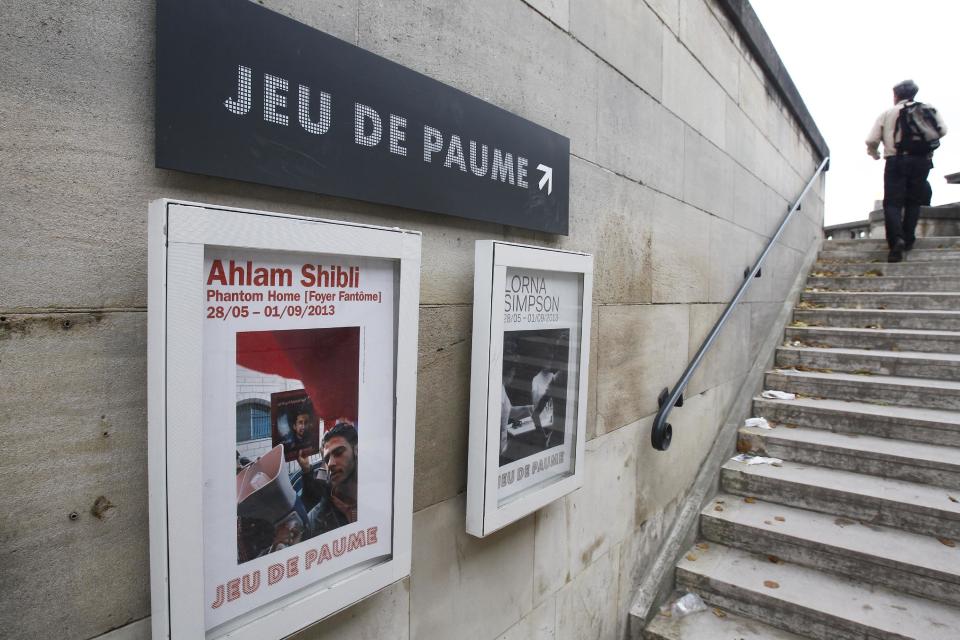 A poster of the exhibit Phantom Home, by Palestinian photographer Ahlam Shibli, is visible outside the Jeu de Paume museum in Paris, Wednesday June 12, 2013. The exhibit which started last week at the Jeu de Paume, features dozens of photographs with captions that glorify dead members of Palestinian groups. (AP Photo/Remy de la Mauviniere)
