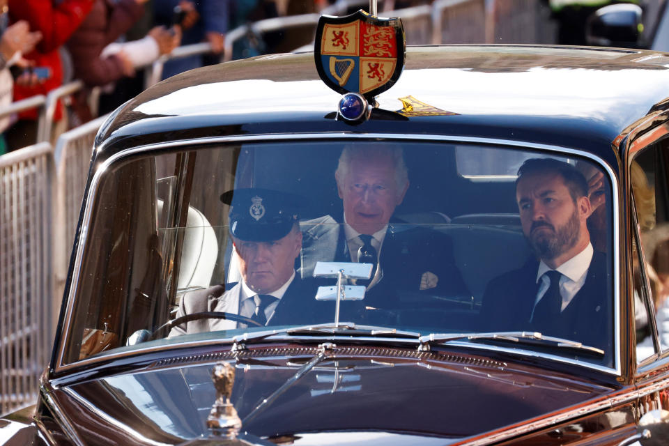 Britain's King Charles III, center, and Camilla, the Queen Consort are driven along the Royal Mile towards the Palace of Holyroodhouse, in Edinburgh, Scotland, Monday, Sept. 12, 2022. King Charles arrived in Edinburgh on Monday to accompany his late mother’s coffin on an emotion-charged procession through the historic heart of the Scottish capital to a cathedral where it will lie for 24 hours to allow the public to pay their last respects. (Odd Andersen/Pool Photo via AP)