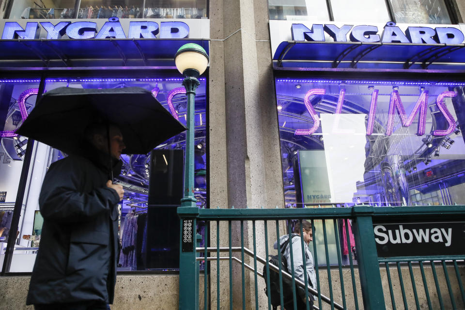 Pedestrians pass the storefront of Peter Nygard's Times Square headquarters, Tuesday, Feb. 25, 2020, in New York. Federal authorities on Tuesday, Feb. 25, 2020, raided the Manhattan headquarters of the Canadian fashion mogul Peter Nygard amid claims that he sexually assaulted and trafficked dozens of teenage girls and young women. (AP Photo/John Minchillo)