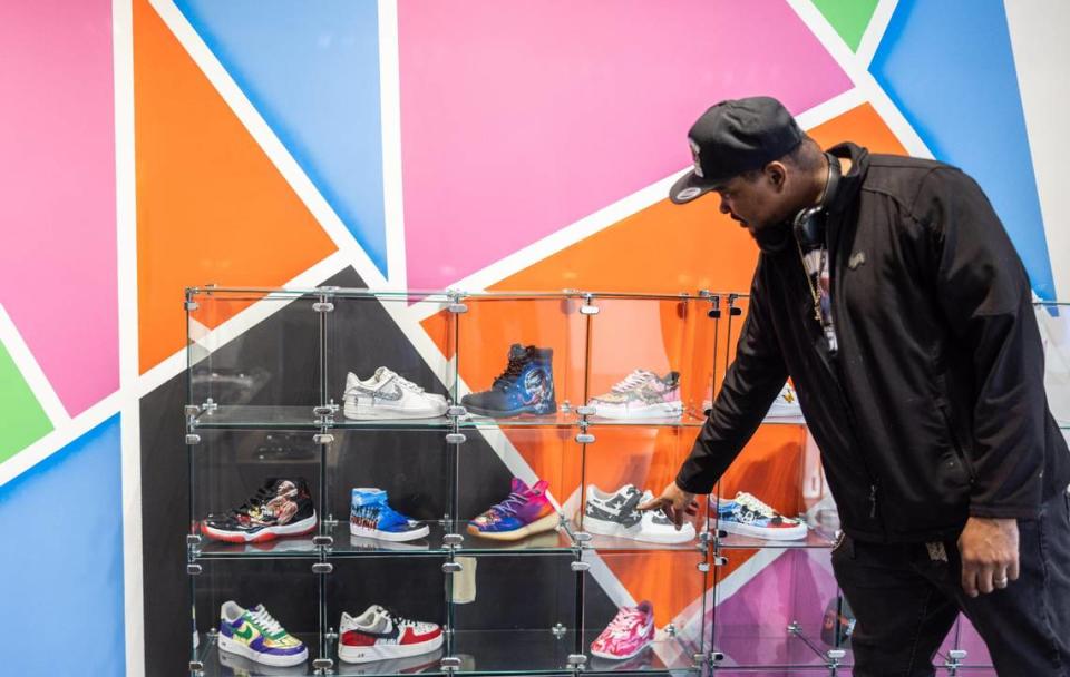 Danyell Butler, co-owner of Modified Kicks, shows a display of some sneakers at Modified Kicks in Northlake Mall in Charlotte.