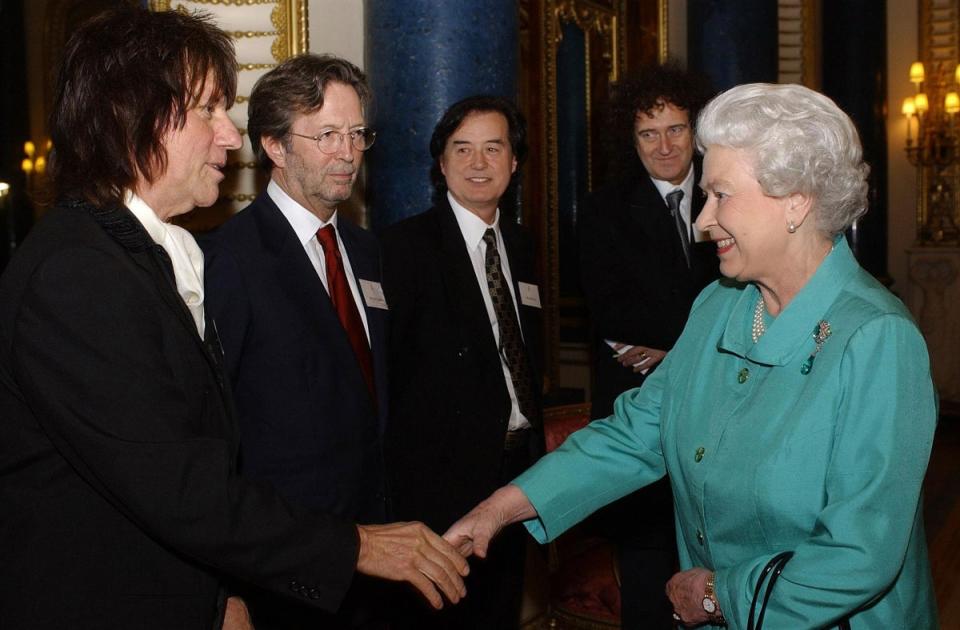 Queen Elizabeth II meets legendary guitarists Jeff Beck (L), Eric Clapton (2nd L), Jimmy Page (C) and Brian May (2nd R) during a reception at Buckingham Palace in London, 1 March 2005 (AFP via Getty Images)