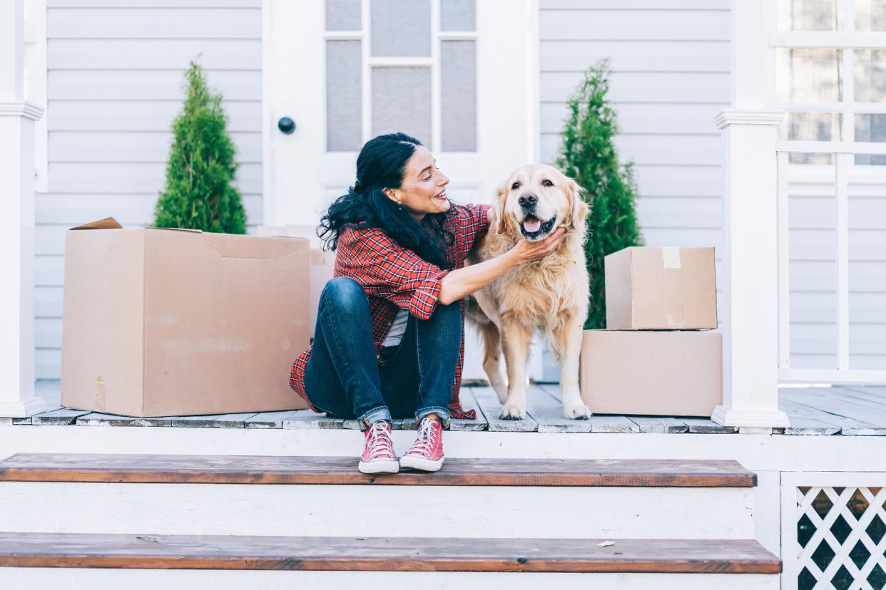 woman outside home with moving boxes