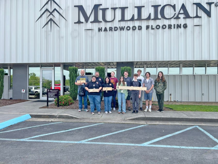 Science Hill High School students display the commemorative wood planks given to them during their visit to Mullican Flooring’s Johnson City facility
