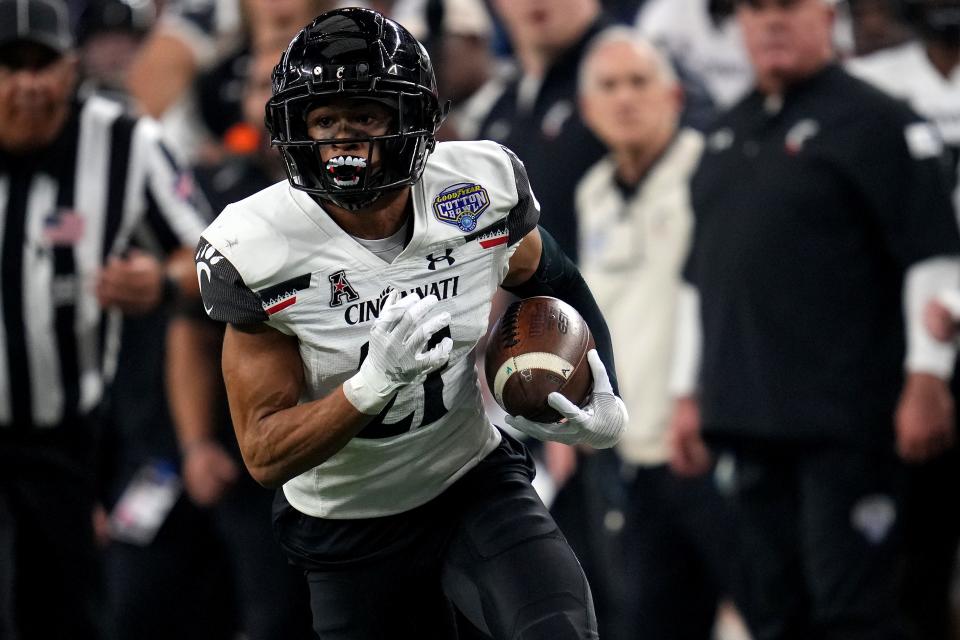 Cincinnati Bearcats wide receiver Tyler Scott (21) runs after a made catch in the first quarter during the College Football Playoff semifinal game against the Alabama Crimson Tide at the 86th Cotton Bowl Classic, Friday, Dec. 31, 2021, at AT&T Stadium in Arlington, Texas.