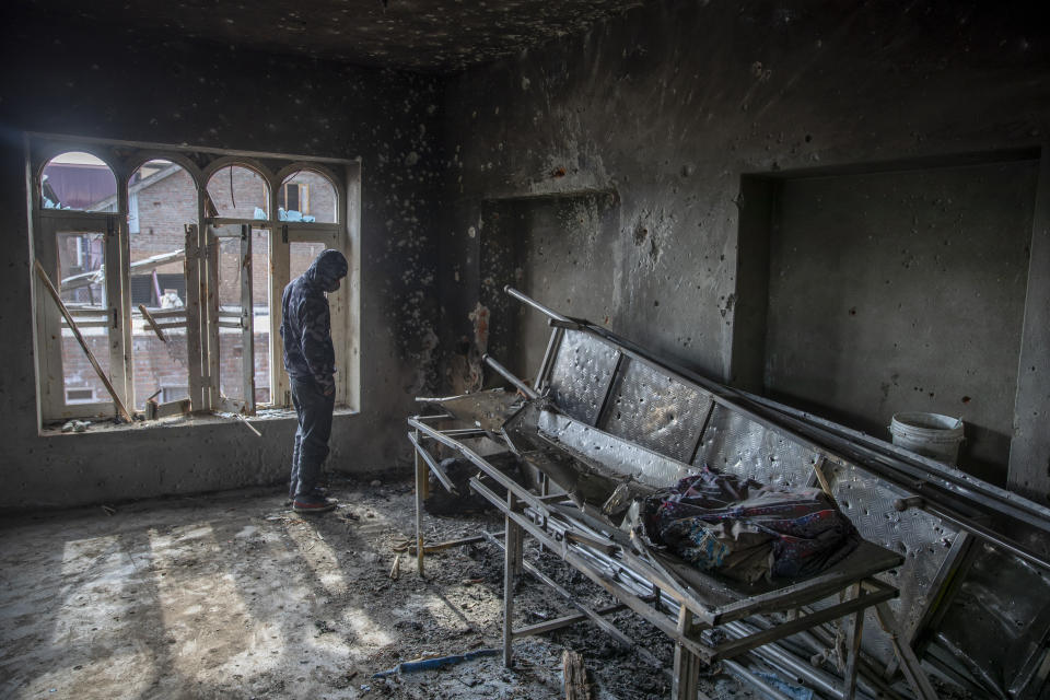 A Kashmiri villager inspects a mosque partially damaged during a gunbattle between Indian soldiers and suspected militants in Shopian, south of Srinagar, Indian controlled Kashmir, Friday, April 9, 2021. Seven suspected militants were killed and four soldiers wounded in two separate gunfights in Indian-controlled Kashmir, officials said Friday, triggering anti-India protests and clashes in the disputed region. (AP Photo/ Dar Yasin)