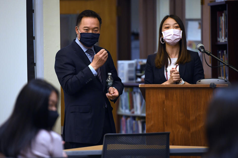 In this Monday, May 10, 2021 photo, Connecticut Attorney General William Tong, left and teacher Clarissa Tan, right, listens as a student asks a question during a program for Asian Pacific American Heritage Month at Farmington High School in Farmington, Conn. The year of anti-Asian violence has led students and teachers to advocate for reexamining how Asian American studies and history are taught in public schools. (AP Photo/Jessica Hill)