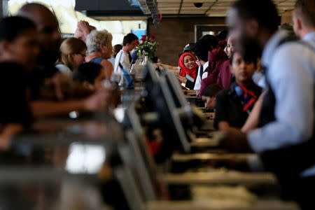 FILE PHOTO: Airlines workers check passengers in for flights at the ticket counter at Dulles International Airport in Dulles, Virginia, U.S. September 24, 2017. REUTERS/James Lawler Duggan/File Photo