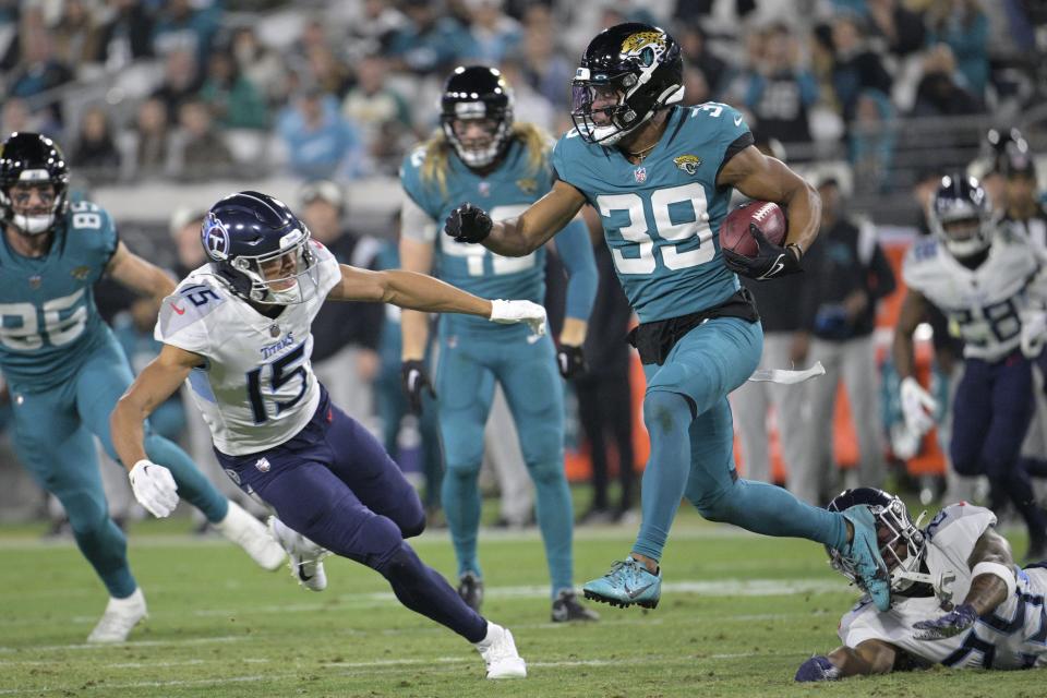 Jacksonville Jaguars wide receiver Jamal Agnew (39) returns a kickoff against Tennessee Titans Nick Westbrook-Ikhine (15) in the second half of an NFL football game, Saturday, Jan. 7, 2023, in Jacksonville, Fla. (AP Photo/Phelan M. Ebenhack)