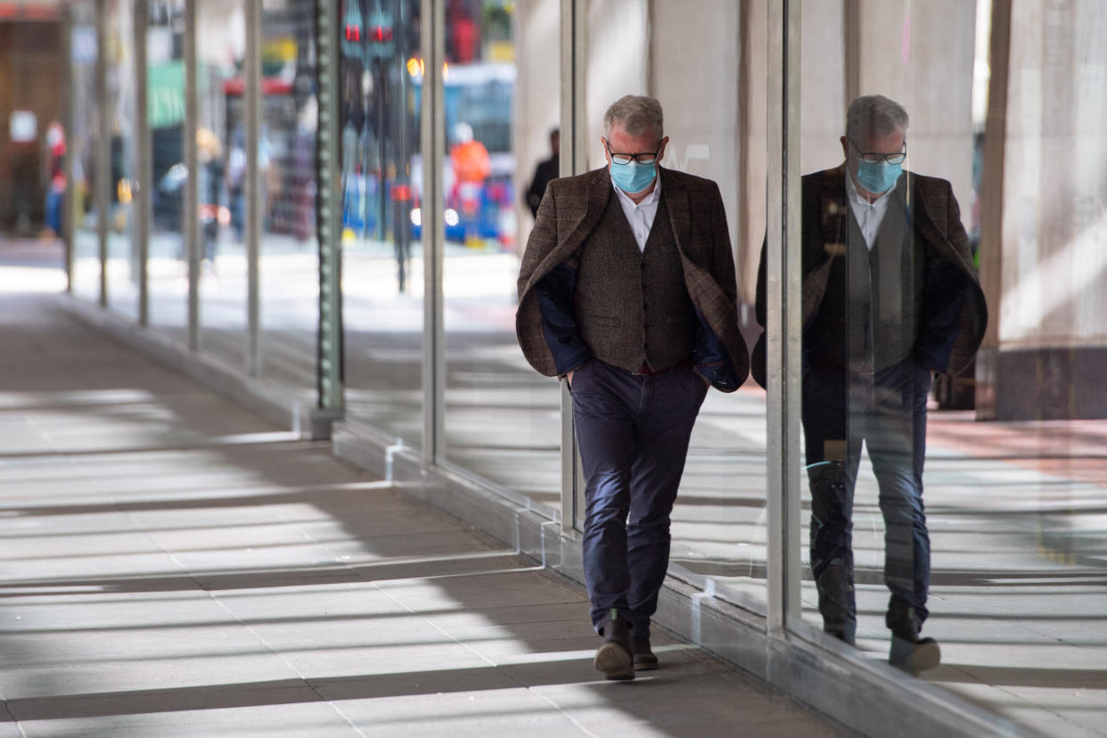 A man wearing a protective face mask passes closed non-essential shops in central London, as England continues to ease coronavirus restrictions. Picture date: Tuesday April 6, 2021. Prime Minister Boris Johnson faces a battle over plans to introduce �vaccine passports� for people to demonstrate their Covid-19 status, using a smartphone app.