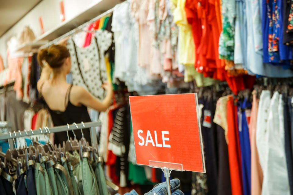 Woman looking clothes on discount in the shopping mall, seasonal sale concept