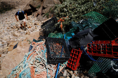 Miguel Lacerda, 62, collects trash at a beach at the coast near Sintra, Portugal May 22, 2019. REUTERS/Rafael Marchante