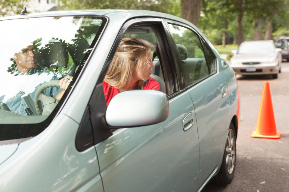 a person taking the parallel parking portion of a driving test