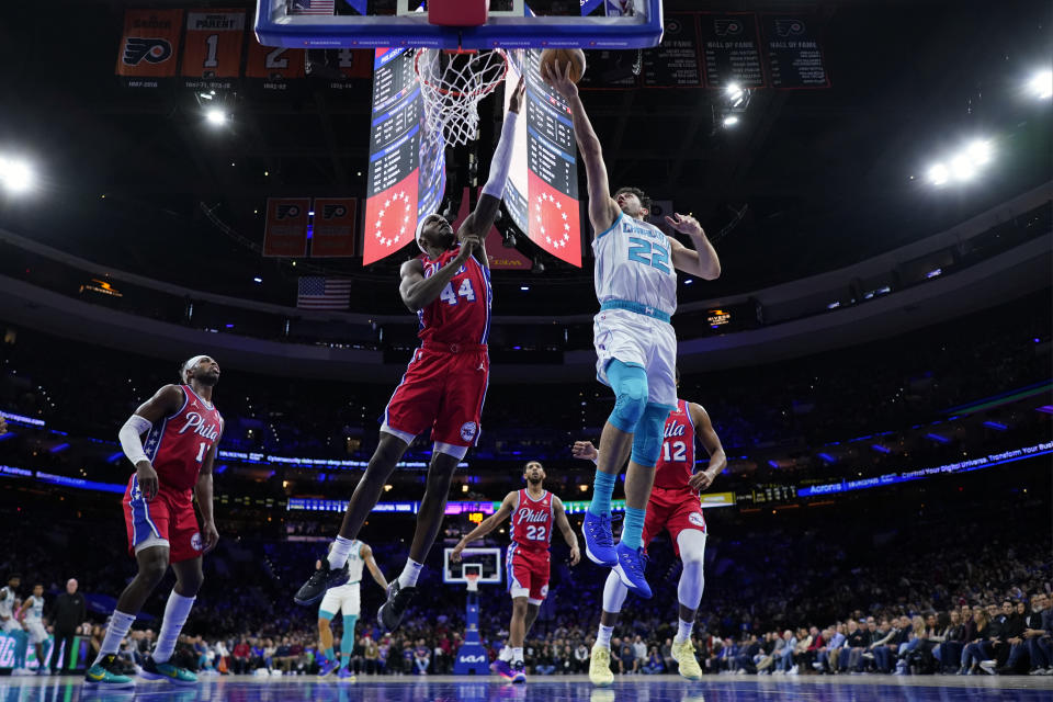 Charlotte Hornets' Vasa Micic, right, goes up for a shot against Philadelphia 76ers' Paul Reed during the first half of an NBA basketball game, Friday, March 1, 2024, in Philadelphia. (AP Photo/Matt Slocum)