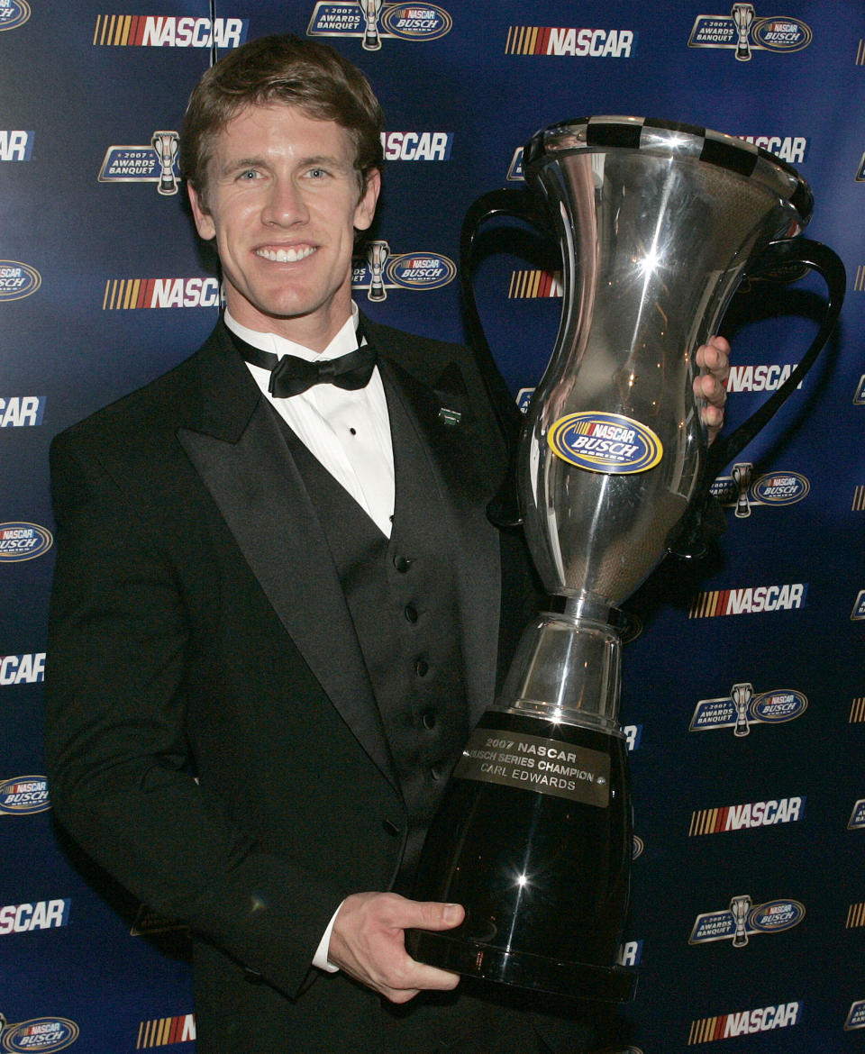 FILE - Champion Carl Edwards poses with his trophy at the NASCAR Busch Series auto racing awards banquet in Orlando, Fla., Friday, Dec. 7, 2007. Edwards, one of NASCAR’s top 75 drivers, was elected to the NASCAR Hall of Fame last week based on his 28 career Cup victories. He said his election to the Hall was a surprise he didn’t see coming. (AP Photo/Reinhold Matay, File)