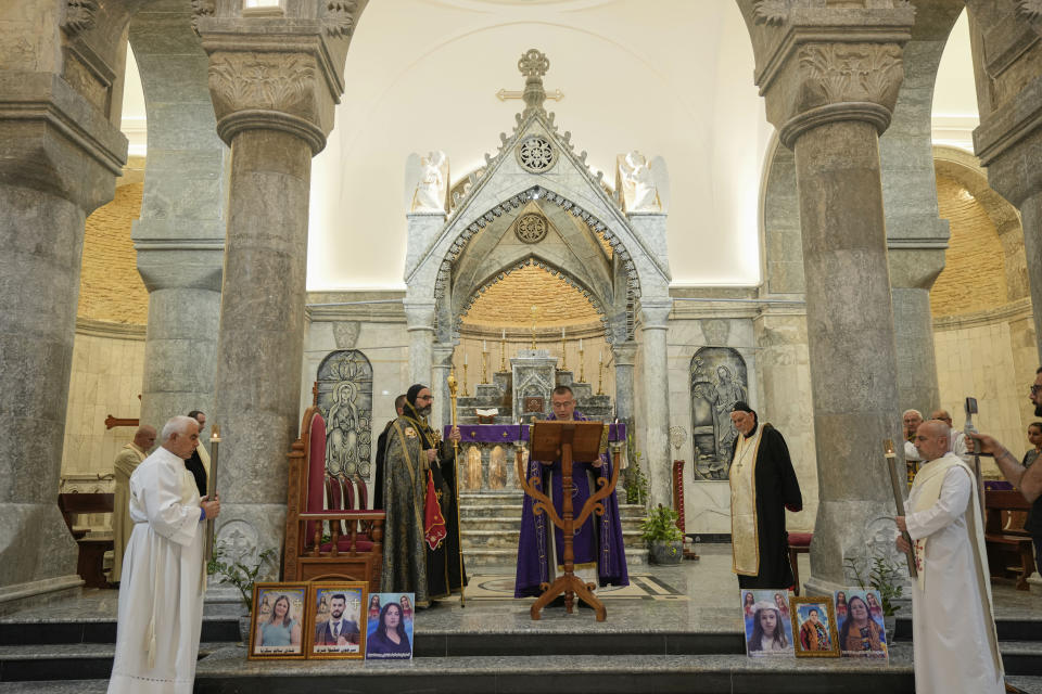 Members of the clergy hold a mass at the Grand Immaculate Church, of Hamdaniya, Nineveh province, Iraq, Friday, Sept. 29, 2023. Iraq's prime minister on Thursday visited injured patients and the families of victims in northern Iraq days after a deadly wedding fire killed around 100 people. (AP Photo/Hadi Mizban)