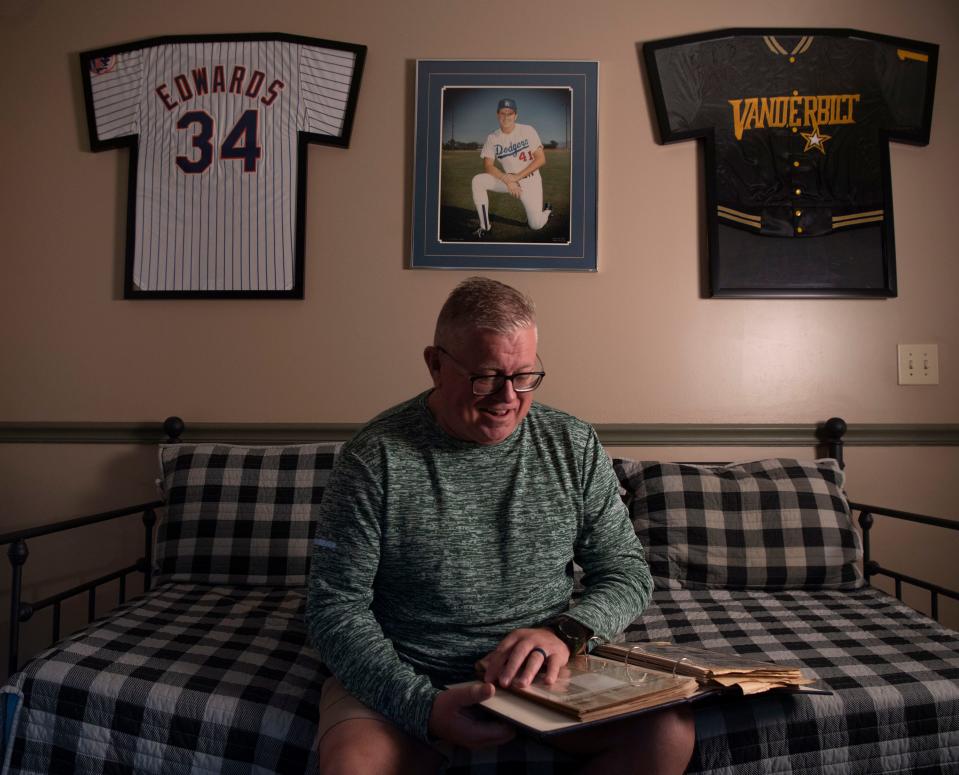 Jeff Edwards, looks through a photo album of old newspaper clippings and other items from when he played baseball at his home in Mt. Juliet, Tenn., Thursday, March 28, 2024.