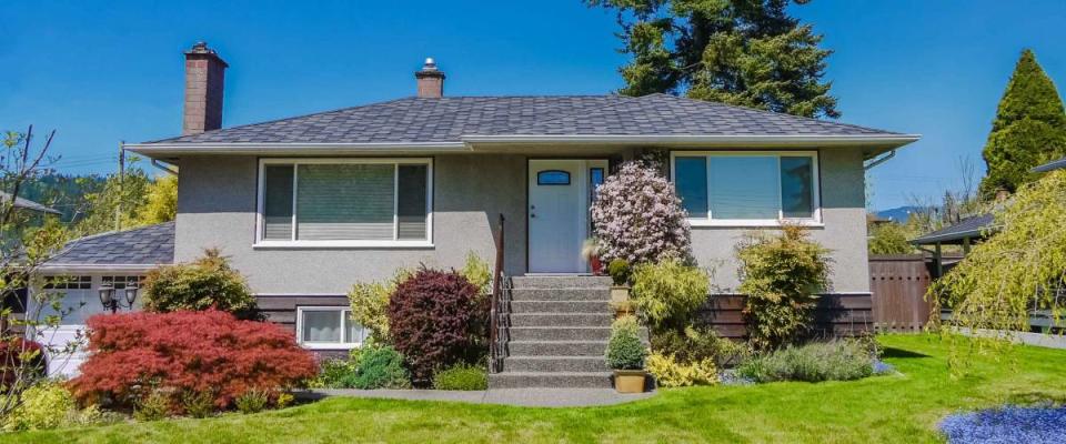 Modest family house with blossoming flowers on the front yard