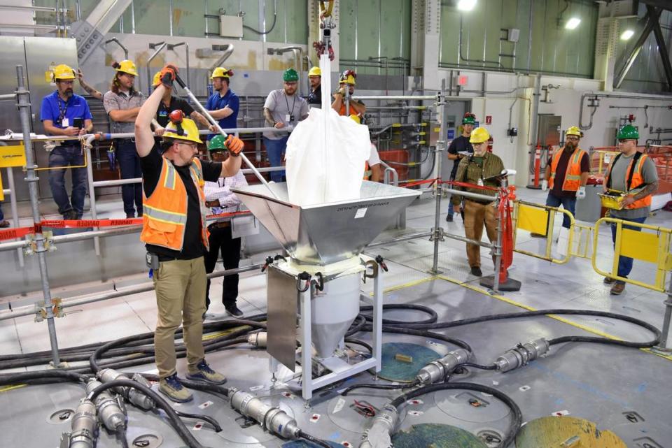 Workers at the Hanford site vitrification plant add frit, or glass beads, to the first melter inside the Low-Activity Waste Facility as preparations are made to glassify radioactive waste.