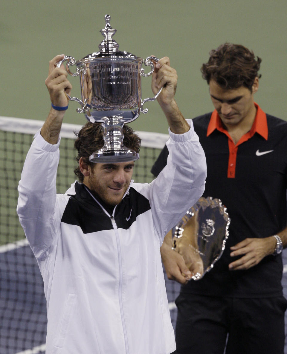 FILE - Juan Martin del Potro, of Argentina, holds up the championship trophy after winning the men's finals championship over Roger Federer, right, of Switzerland, at the U.S. Open tennis tournament in New York, Sept. 14, 2009. Juan Martín del Potro is hoping for one final Grand Slam hurrah at the U.S. Open. (AP Photo/Elise Amendola, File)