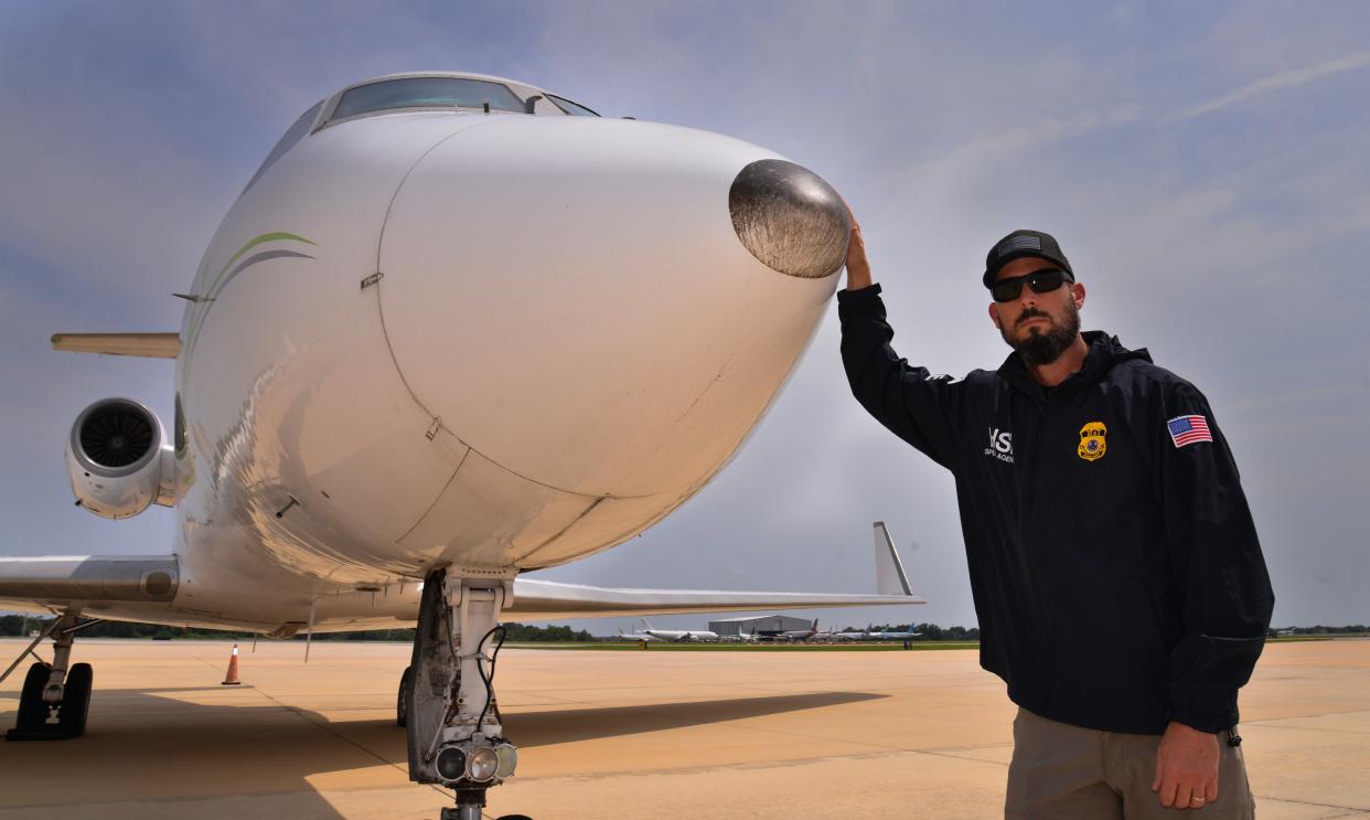 Ryan Gorman, a special agent with the Homeland Security Investigations, stands by a Gulfstream G-3 jet on the tarmac outside a private hangar at Orlando Sanford International Airport. The jet was seized from drug dealers. The plane has since been sold at auction and is owned by legitimate owners now.  