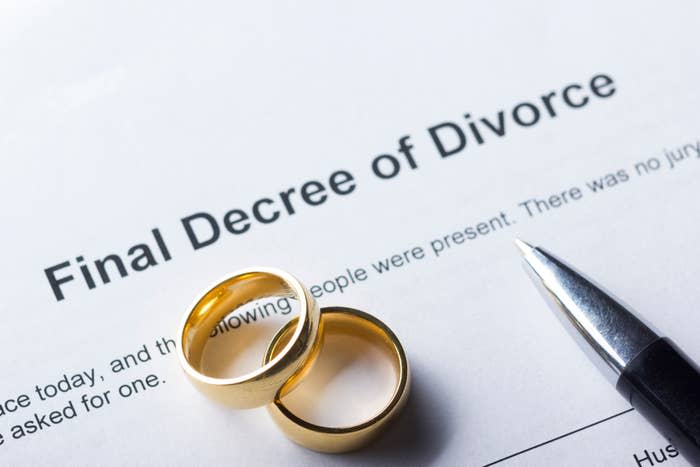 Two wedding rings are placed on a document titled "Final Decree of Divorce" next to a pen