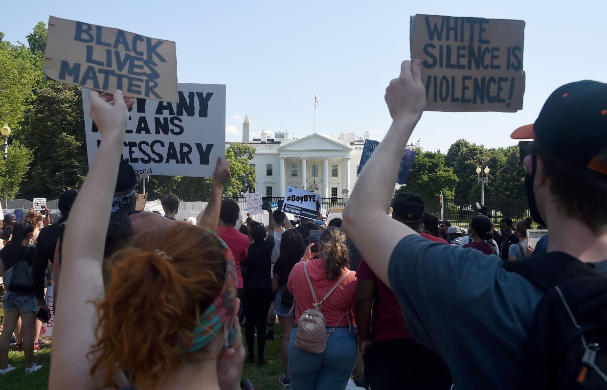 Protesters hold placards in Lafayette Park, across from the White House to protest against police brutality and US President Donald Trump's 74th birthday on June 14, 2020 in Washington, DC (AFP via Getty Images)