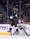 Los Angeles Kings left wing Tanner Pearson, top, jumps to stop a puck as Buffalo Sabres goalie Jhonas Enroth, of Sweden, looks on during the first period of an NHL hockey game, Thursday, Oct. 23, 2014, in Los Angeles. (AP Photo/Mark J. Terrill)