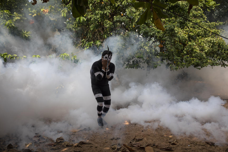 An actor who was hired by the government to assume the role of a mosquito is engulfed by clouds of pesticide during a fumigation campaign against dengue in Pucallpa, in Peru's Ucayali region, Saturday, Oct. 3, 2020. Dengue is a mosquito-borne disease also known as "breakbone fever" for its severely painful symptoms. (AP Photo/Rodrigo Abd)